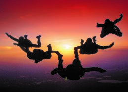 Silhouette of five people skydiving